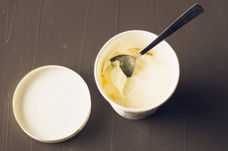 ice cream. ice cream in a jar on a dark table. Spoon on ice cream. Sweet dessert. Top view