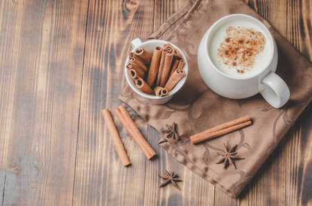 Eggnog. Traditional christmas cocktail in a white mug with cinnamon sticks  and anise on a napkin.の写真素材