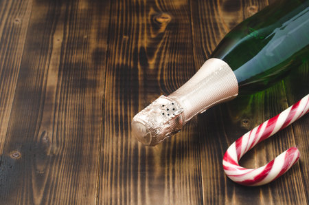 Holiday Bottle of champagne and candy canes over woodenの写真素材