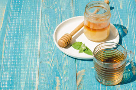 tea with mint and honey on a wooden blue table background. Copy space. Selective focusの写真素材