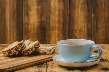 Breakfast with tea cup and pastries sliced on wooden board on a table. Selective focusの写真素材