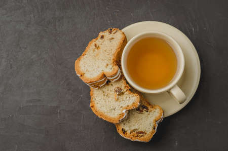 Tea cup and pastries piece on dark stone table. Top view and copyspaceの写真素材