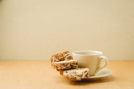 Tea cup and pastries piece on wooden table. Breakfast. Selective focus
