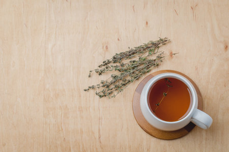 Thyme herbal tea on a wooden table, top view, space for a textの写真素材