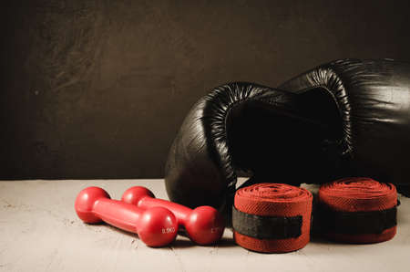 black boxing gloves and red dumbbells and bandage / sport concept with black boxing gloves and red dumbbells and bandageの写真素材