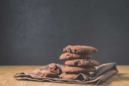 Chocolate cookies on wooden table/Chocolate cookies on wooden table on a dark background with copy spaceの写真素材