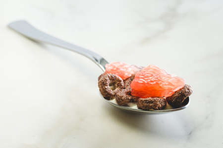 Healthy food concept. Yogurt, flakes and grapefruit pieces in a spoonの写真素材
