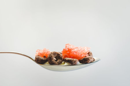 Healthy food concept. Yogurt, flakes and grapefruit pieces in a spoon