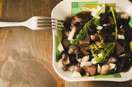 mushrooms in a plate on a wooden table, top view. Rustic style