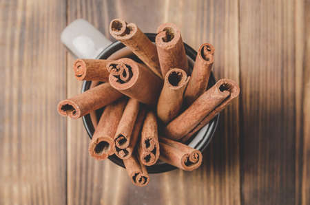 Cinnamon sticks. Top view. Seasoning. Cinnamon sticks in a mug on a wooden table. の写真素材