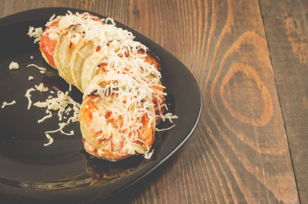 vegetable stew from tomatoes of vegetable marrows and meat trewed with cheese on a black bowl....
