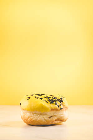 Donut. Assorted donut lying on a white table on yellow background. Ð¡oncept sweet foodの写真素材