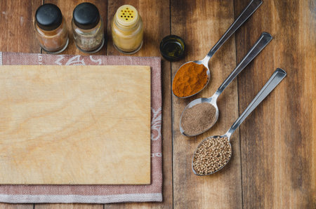 Cooking ingredients. Various spices and cutting board on wooden table. Top viewの写真素材