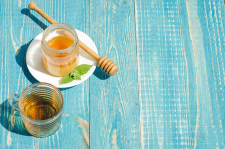 tea with mint and honey on a wooden blue table background. Copy space. Selective focusの写真素材