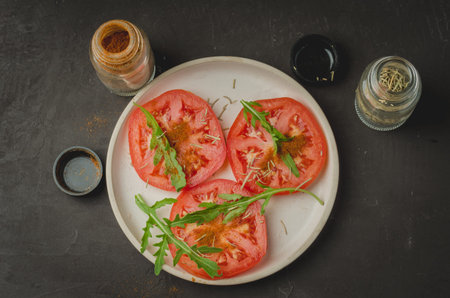 sliced tomatoes and arugula spices salad. Healthy food. Top viewの写真素材
