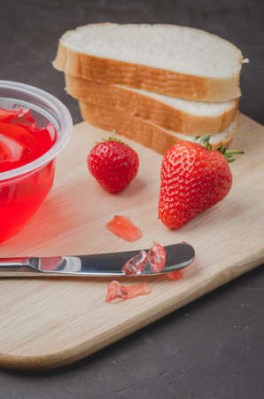 Strawberry pudding. Bread and strawberry pudding on a dark table with jar of pudding and fresh strawberry.の写真素材