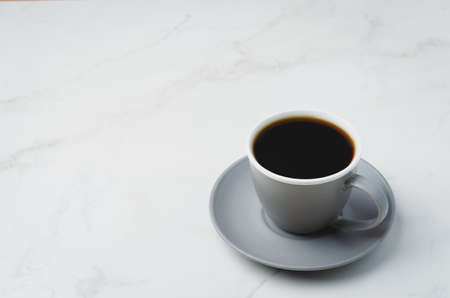Grey cup with black coffee on on white table. Copyspace. Coffee break.の写真素材