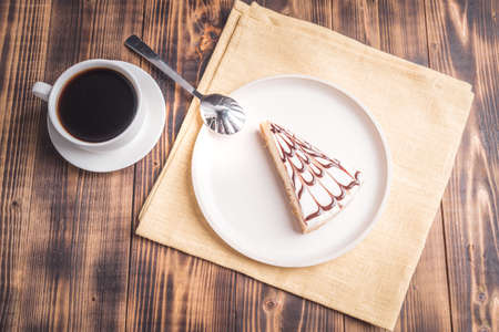 Cheesecake on a white plate with a cup of coffee. Top view.の写真素材