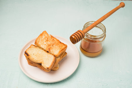 Croutons are cut on a board, a jar and a wooden spoon for honey. top view.