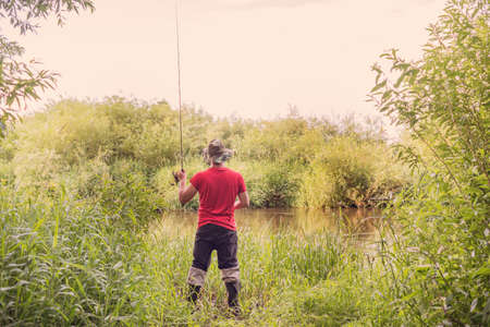 Fisherman throws a spinning view from the back. summer fishing.の写真素材