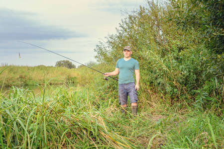 Outdoor sports hobby fishing. Happy fisherman fishing on the River.の写真素材