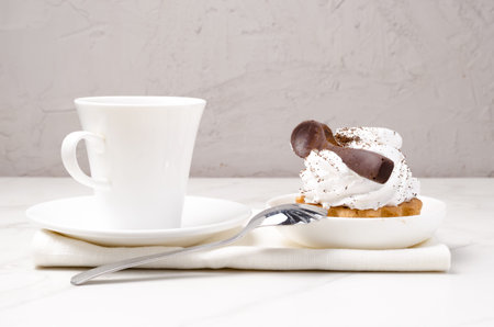 Cake basket with protein white cream decorated with a chocolate spoon in a white plate on a napkin...