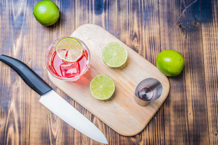Red cocktail with lime on a wooden table. top view.の写真素材