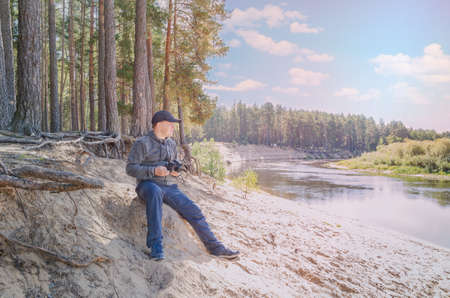 Photographer relaxes in nature near the river. outdoor recreation.の写真素材