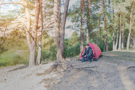 Man sitting in the forest near the tent. outdoor camping.の写真素材