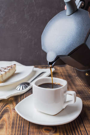 Coffee is poured from a geyser coffee maker into a cup.の写真素材
