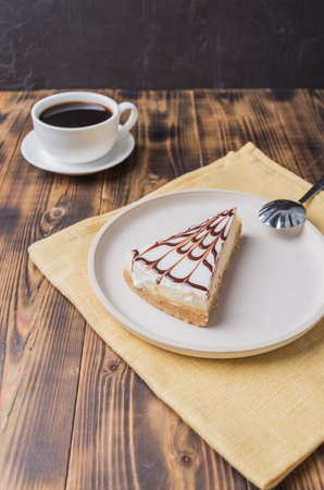 Cheesecake on a white plate with a cup of coffee.の写真素材
