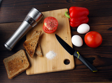 Bulgarian pepper, tomato, eggs and bread on the table.