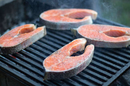 One grilled salmon fish steak barbecue meal cooking, prepared on bbq grill, close up.の写真素材