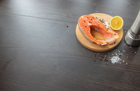 Raw salmon steak cooked for cooking. Top view on a black wooden table.の写真素材