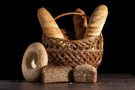 Freshly baked wheat bread, still life with bread, crisp loaf of bread, still life on a rustic background, side view, a loaf of bread with grains.の写真素材