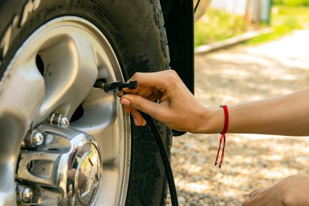 A girl shakes a flat tire on a car. Selective focus.