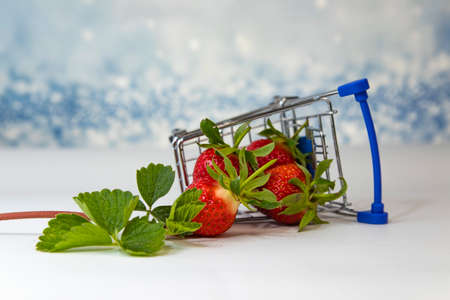 Strawberries in a small supermarket trolley. Fresh red strawberries. Strawberries in an inverted cart.の写真素材