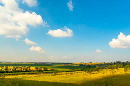 Beautiful view from the hill on the blue sky, the river and agricultural fields extending beyond the horizon.の写真素材