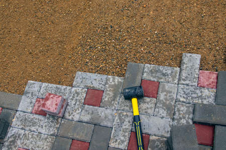Laying gray concrete paving slabs in a courtyard patio driveway house. Professional workers are installing new tiles or slabs for the driveway, Selective focus.の写真素材