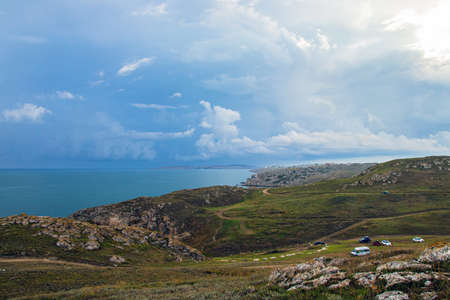 Sunlight on the coast in autumn with clouds and blue sky. sandy beach in the bay. Landscape with beach, sea and beautiful clouds in the blue skyの写真素材