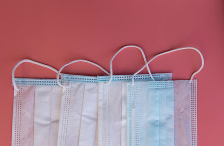 Several medical masks on a pink background. Medical concept