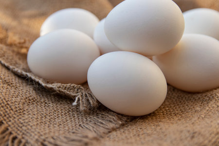 Organic raw chicken eggs on burlap cloth. Fresh chicken eggs.