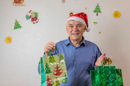 Christmas shopping online.   A man in a suit and Santa Claus hats makes purchases on the Internetの写真素材