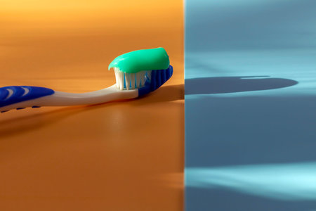 A shot of a toothbrush with toothpaste, side view illuminated by the rays of the sun. Place for...