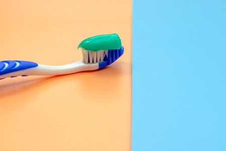 toothbrush with toothpaste on a colored background. Side view, selective focus, space for textの写真素材