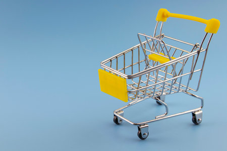 small cart on turquoise background, copy space, shopping conceptの写真素材