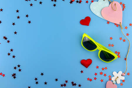 Top view of yellow and black sunglasses, two linked hearts concept of the approaching summer.の写真素材