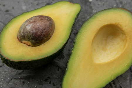 Fresh cut avocado on a dark table.