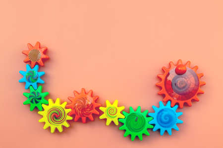 Teamwork and solidarity concept related colorful plastic toy gears, each gear is a different color on a blue background with copy spaceの写真素材