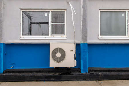 A / C condenser and piping on the building wallの写真素材